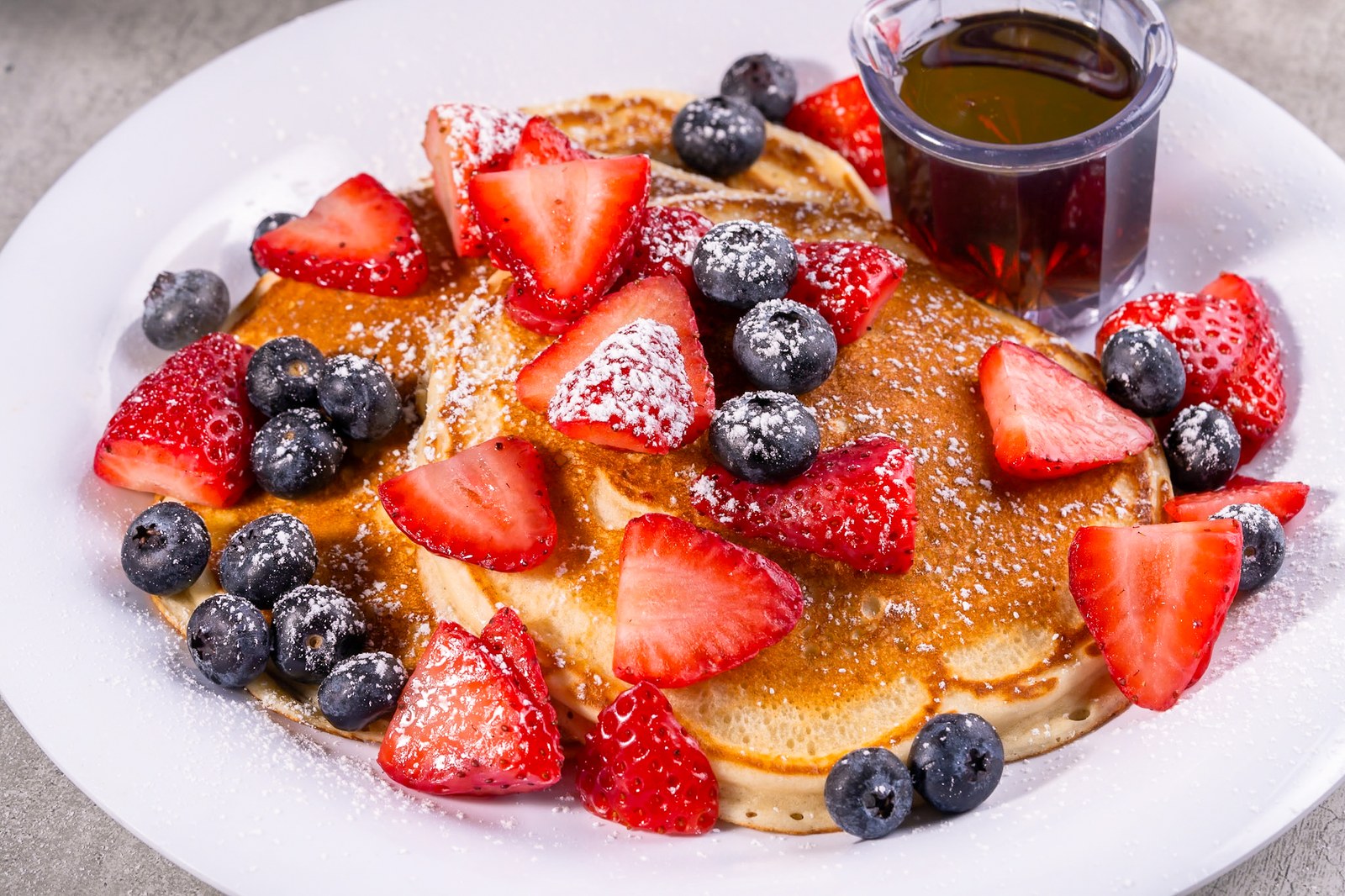 Sami's pancakes with fresh strawberries, blueberries and maple syrup