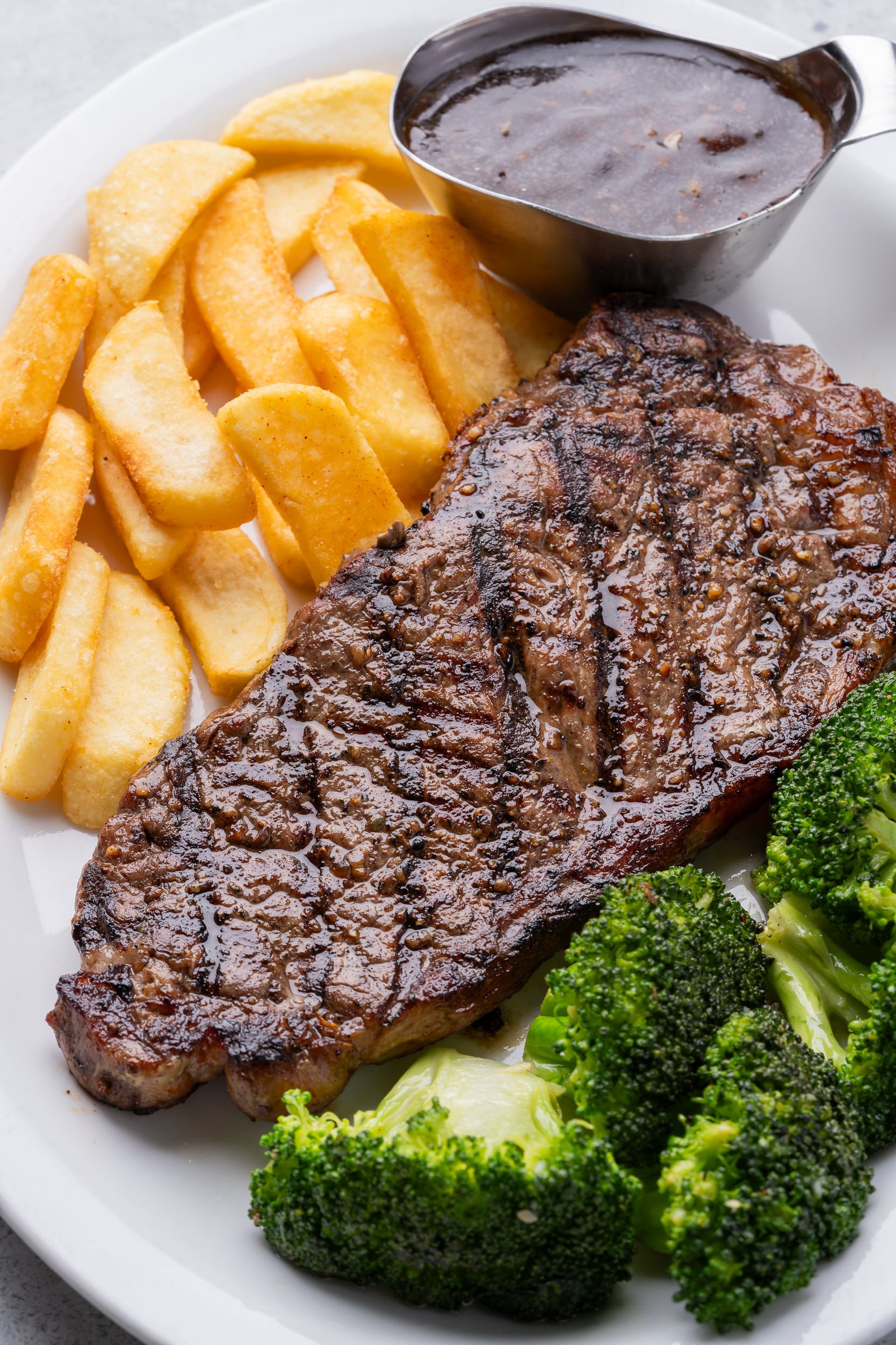 Ribeye steak with fries and broccoli
